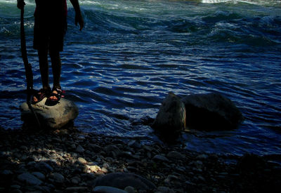 Low section of woman standing in water