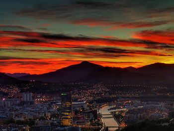 High angle view of illuminated city against sky during sunset