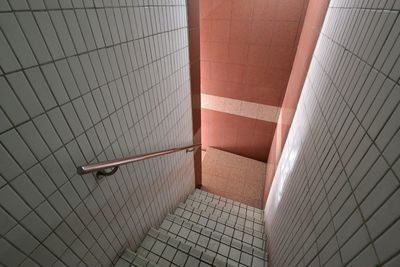 Directly above shot of steps amidst tiled wall