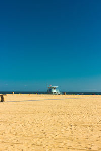 Scenic view of beach against clear blue sky