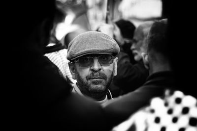 Man wearing cap amidst crowd in city