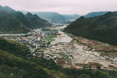 High angle view of townscape by mountain against sky