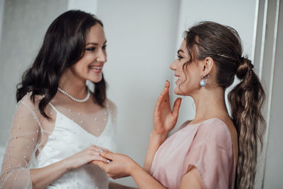 Bridesmaid grooming bride