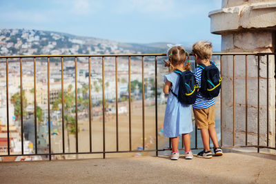 Full length of young woman standing against railing