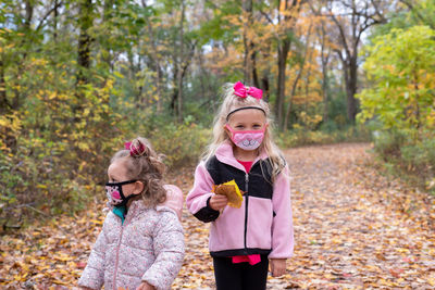 Happy girl smiling while standing on autumn leaves