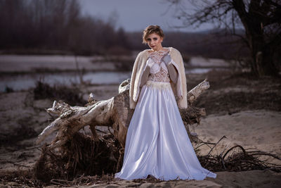 Portrait of young woman standing on field