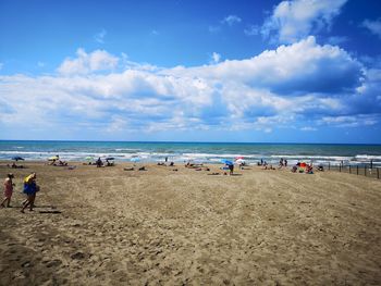 Group of people on beach against sky