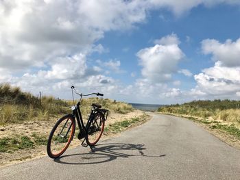 Bicycle on road against sky