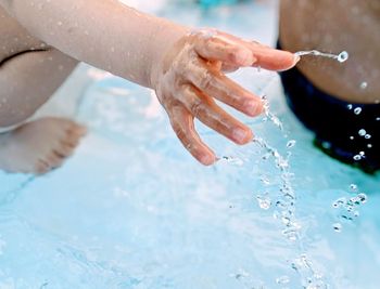 Close-up of hand on swimming pool
