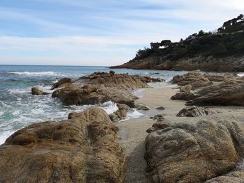 Rocks on beach against sky