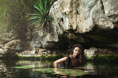 Portrait of young woman in waterfall