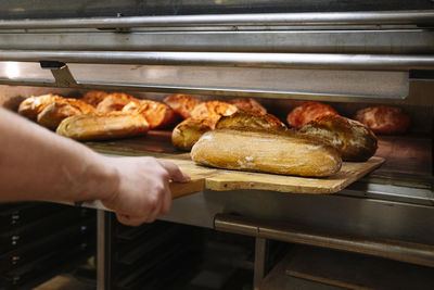 Close-up of person preparing food on barbecue grill