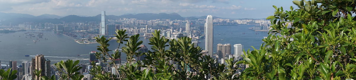 Panoramic view of city by sea against sky