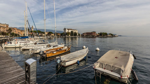 Sailboats moored at harbor