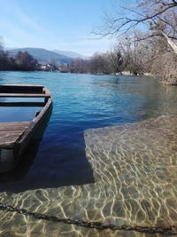 Swimming pool by lake against sky