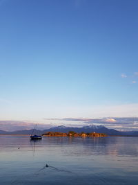 Sailboats in sea against sky during sunset