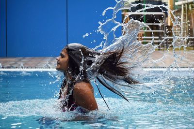 Woman splashing in swimming pool