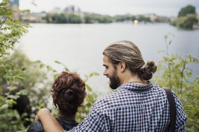 Rear view of couple looking at river