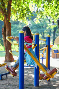 Low angle view of girl playing on slide at playground
