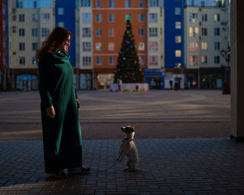 Rear view of woman with dog on street