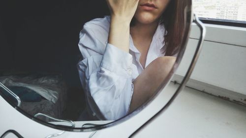 Reflection of woman seen in mirror at home