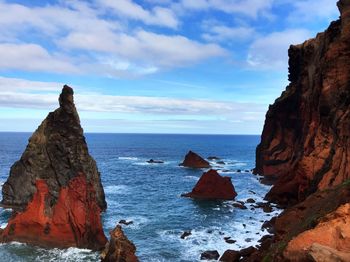 Rock formations in sea against sky