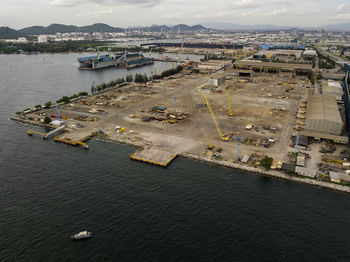 Aerial logistics commercial vehicles waiting to be load on to a car carrier ship at dockyard