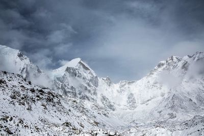 Scenic view of snow covered mountains against cloudy sky