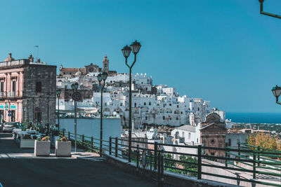 Buildings in city against clear blue sky