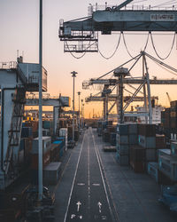 Low angle view of cranes at construction site during sunset