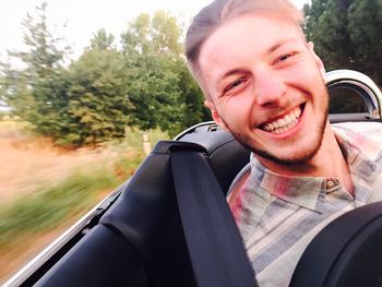 Portrait of smiling young man in car