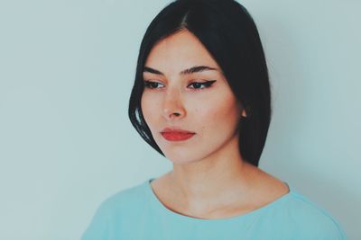 Portrait of young woman against white background