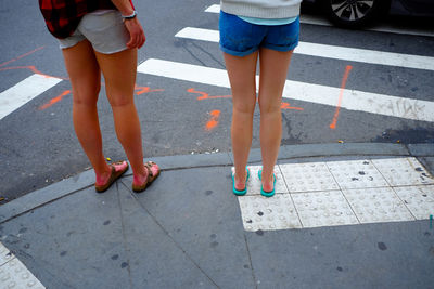 Low section of women standing on street