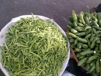 High angle view of sponge gourds and green beans for sale at street market