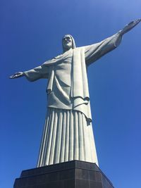 Low angle view of statue against blue sky