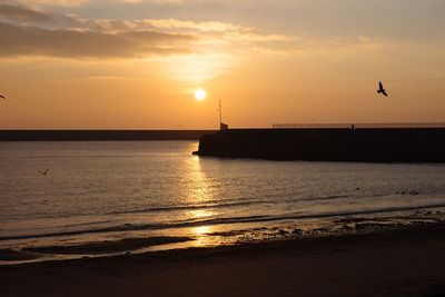 Scenic view of sea against orange sky