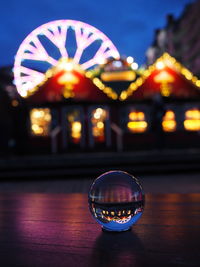 Illuminated ferris wheel against sky at night