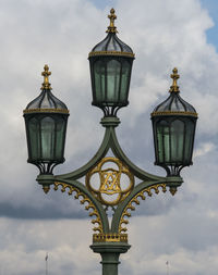 Low angle view of street light against cloudy sky