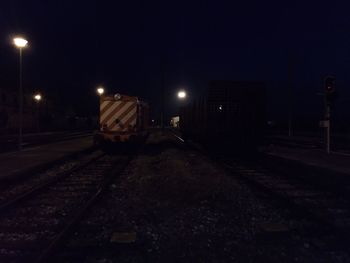 Train at railroad station platform at night