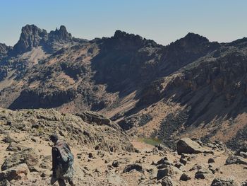 Rear view of person on mountain against sky