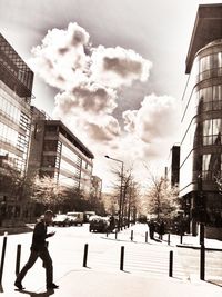 Buildings in city against cloudy sky