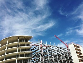 Low angle view of modern building against cloudy sky