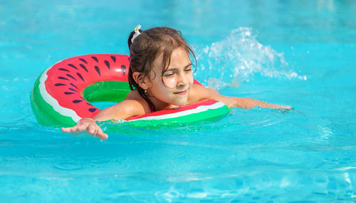 Girl with inflatable ring swimming in pool