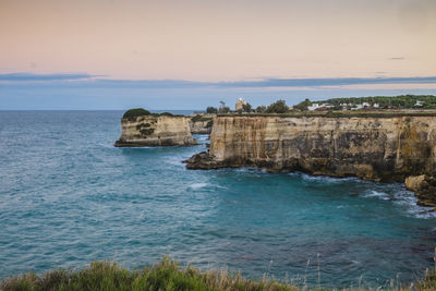 Rock formations by sea against sky 