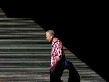 Man looking away while sitting on staircase