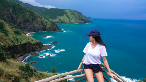 Side view of young woman looking away against lake