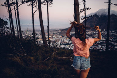 Rear view of woman standing on land against sky