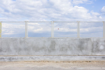 Wall by bridge against sky