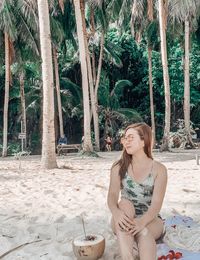 Beautiful young woman sitting on beach