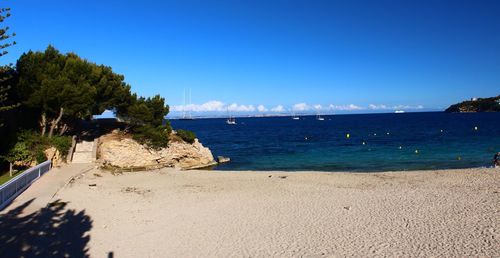 Scenic view of beach against clear blue sky